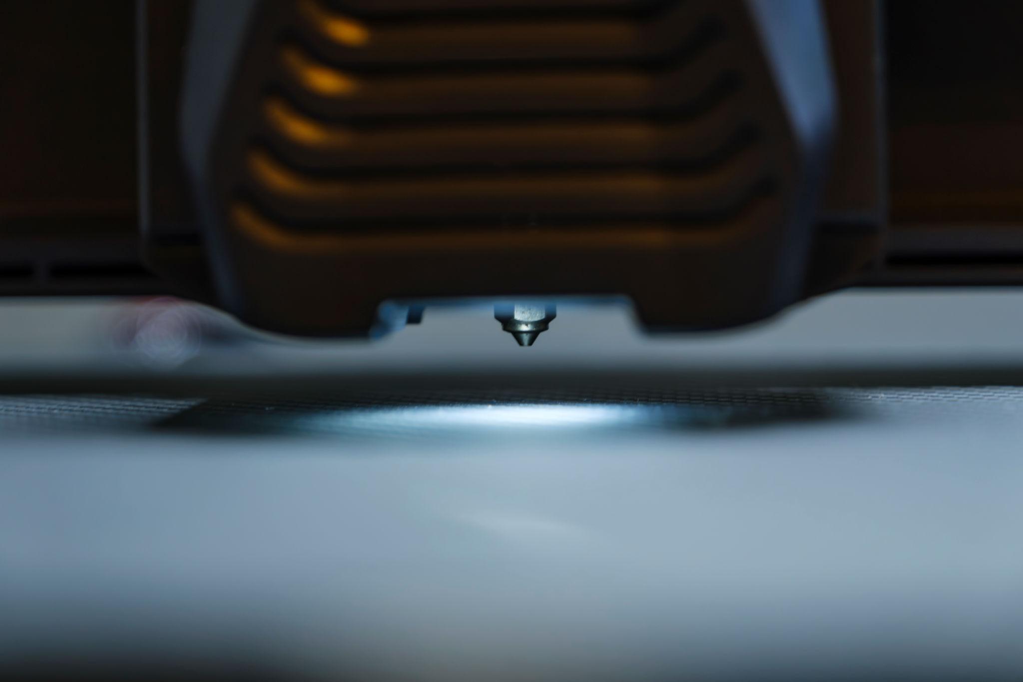 Detalle de una boquilla de impresión 3D sobre la cama de fabricación